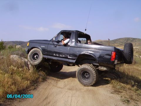 1990 Ford Bronco - 1990 Ford Bronco navigating rough terrain off-road.