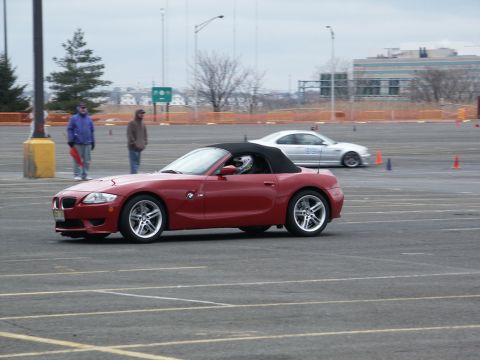 2001 Mercury Grand Marquis - Red convertible sports car navigates a track with another vehicle in the background.