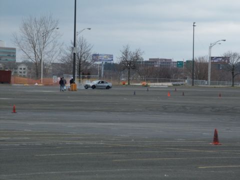 2001 Mercury Grand Marquis - A silver sedan is parked on a paved lot marked with orange cones, suggesting a driving event or practice area.