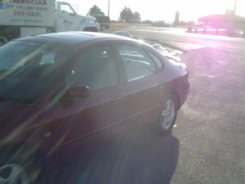 2000 Ford Taurus - Dark red 2000 Ford Taurus sedan seen from the driver's side in a parking lot.