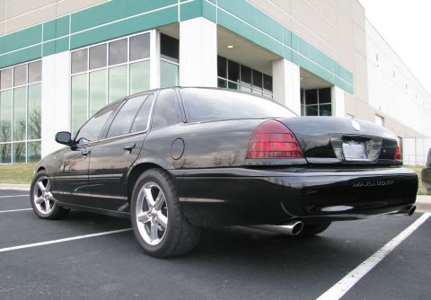 2003 Mercury Marauder - Rear view of a black 2003 Mercury Marauder parked in front of a modern building.