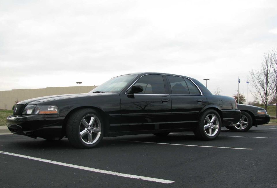 Black Mercury Marauder sedan on chrome wheels in a parking lot
