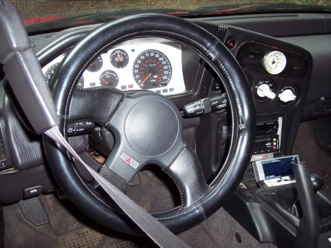 1992 Mitsubishi Eclipse - The dashboard of a 1992 Mitsubishi Eclipse features a prominent steering wheel and a clear view of the instrument cluster.