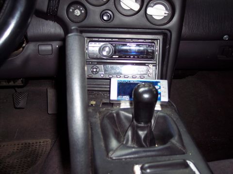 1992 Mitsubishi Eclipse - The center console of a 1992 Mitsubishi Eclipse features an aftermarket stereo and a gear shifter.