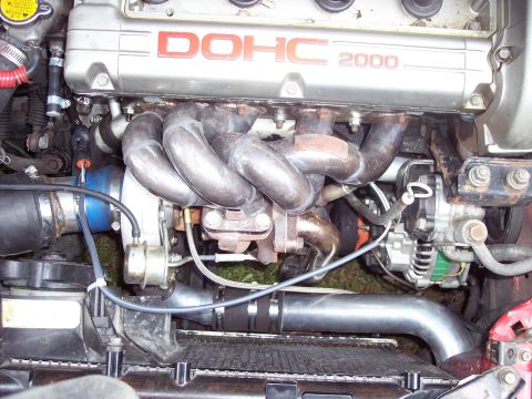1992 Mitsubishi Eclipse - Close-up of a turbocharged engine, identified by DOHC 2000 markings on the valve cover.