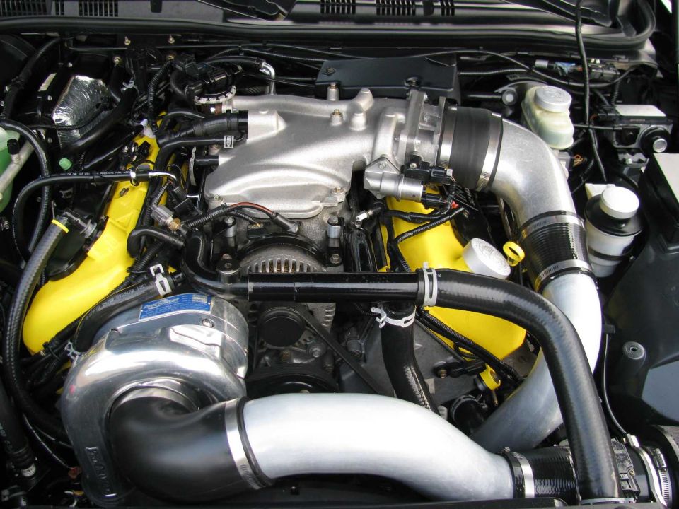V8 engine bay with polished ProCharger supercharger and yellow cam covers