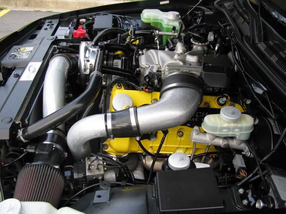 Supercharged V8 engine bay with yellow cam covers, aluminum charge piping and Marauder billet caps