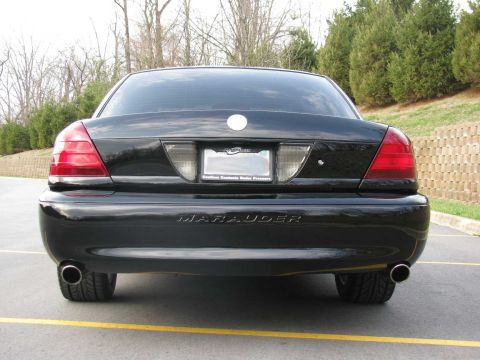 2003 Mercury Marauder - Rear view of a black 2003 Mercury Marauder parked on asphalt with a yellow line.