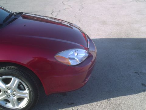 2000 Ford Taurus - Front passenger side view of a red 2000 Ford Taurus, showing the headlight and fender.
