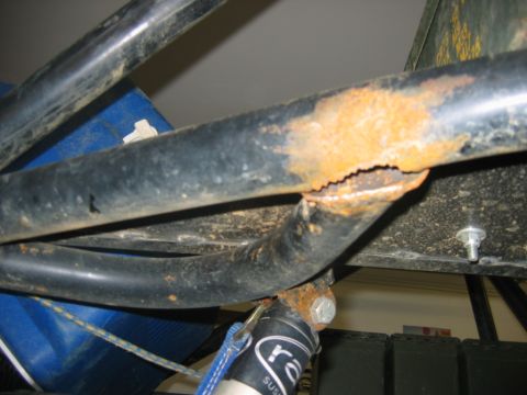 1992 Ford Mustang - Close-up of heavily rusted metal tubing, indicating structural damage or wear.