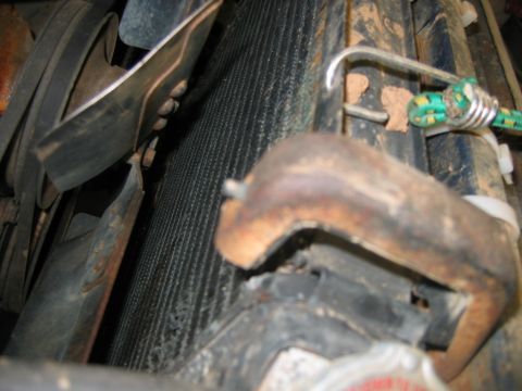 1992 Ford Mustang - Close-up view of a vehicle's radiator and fan assembly, with a bungee cord securing a part.