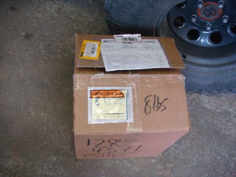 1996 Ford Bronco - Two cardboard boxes are stacked, one on top of the other, with various shipping labels and handwritten markings.
