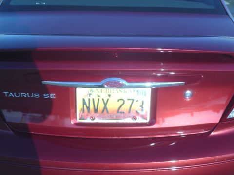 2000 Ford Taurus - The rear of a red sedan, identified as a Taurus SE, is shown with a Nebraska license plate.