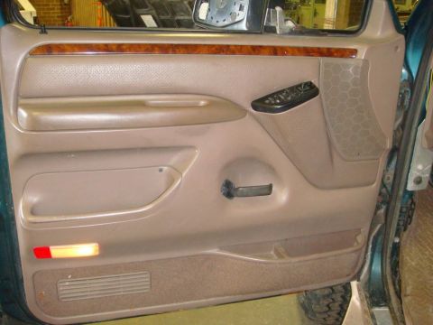 1996 Ford Bronco - Interior door panel of a 1996 Ford Bronco, showing wood trim and power controls.