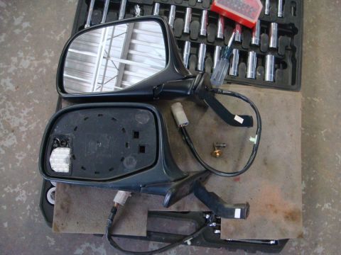 1996 Ford Bronco - Two car side mirrors are shown disassembled, with a set of tools in the background.