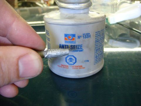 1996 Ford Bronco - A bolt is coated with anti-seize lubricant from a can of Permatex.