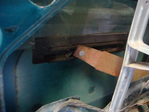 1996 Ford Bronco - Close-up of the internal door mechanism, likely for a window, showing aged and rusty components.