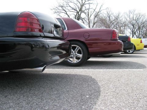 2003 Mercury Marauder - Rear view of a line of sedans including a black car, a maroon car, and a yellow car.