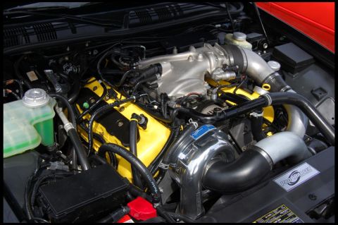 2003 Mercury Marauder - Close-up of a modified engine bay, showing yellow valve covers and a prominent supercharger.