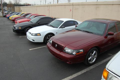 2003 Mercury Marauder - A red 2003 Mercury Marauder is parked in a lot alongside several other vehicles.