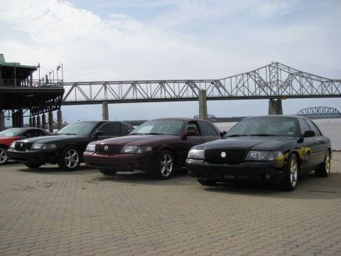 2003 Mercury Marauder - Three 2003 Mercury Marauders are parked side-by-side near a bridge and waterfront building.