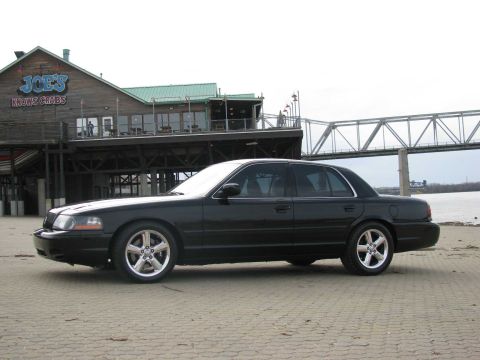 2003 Mercury Marauder - A black 2003 Mercury Marauder is parked on a paved area in front of a seafood restaurant.
