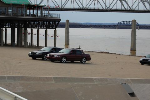 2003 Mercury Marauder - Two 2003 Mercury Marauders are parked near a river, with a large bridge overhead.