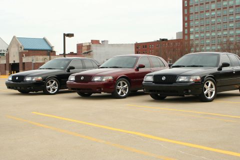 2003 Mercury Marauder - Three 2003 Mercury Marauders are lined up in a parking lot under an overcast sky.