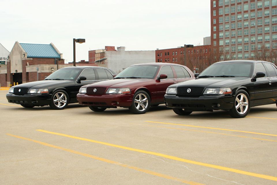 Three black and maroon 2003 Mercury Marauders parked in a lot