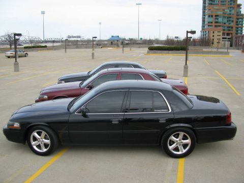 2003 Mercury Marauder - Three sedans are parked in a lot with a building in the background.