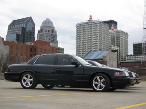 2003 Mercury Marauder - A black 2003 Mercury Marauder is parked in front of a city skyline with multiple buildings.