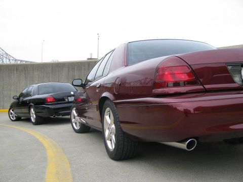 2003 Mercury Marauder - Two sedans, a maroon 2003 Mercury Marauder and a black one, are parked on asphalt with a yellow line visible.