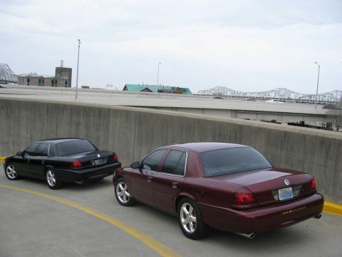 2003 Mercury Marauder - Two 2003 Mercury Marauders are seen parked on a road, with a bridge visible in the distance.