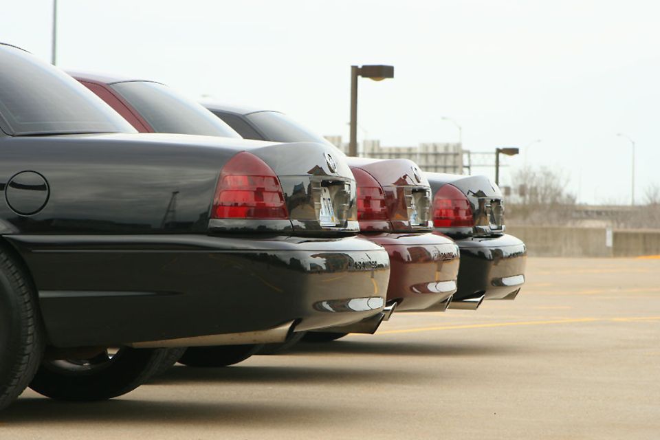 Three sedans parked in a lot, viewed from the rear quarter