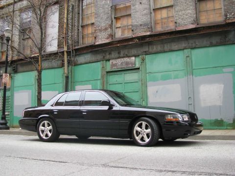 2003 Mercury Marauder - A black 2003 Mercury Marauder is parked on a city street in front of an old brick building with green doors.