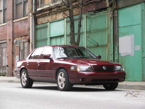 2003 Mercury Marauder - A red 2003 Mercury Marauder is parked on a street in front of a building with green doors.