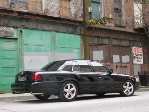 2003 Mercury Marauder - A black 2003 Mercury Marauder is parked in front of old brick buildings with green doors.