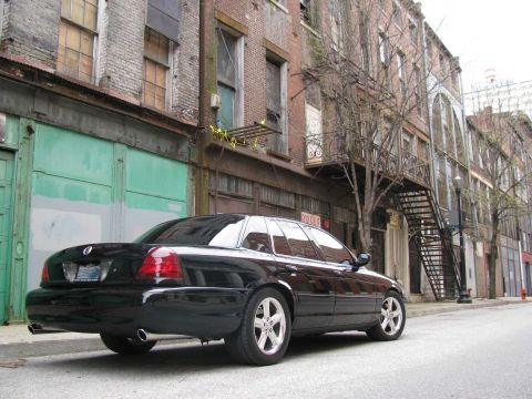 2003 Mercury Marauder - A black 2003 Mercury Marauder is parked on a city street with brick buildings in the background.