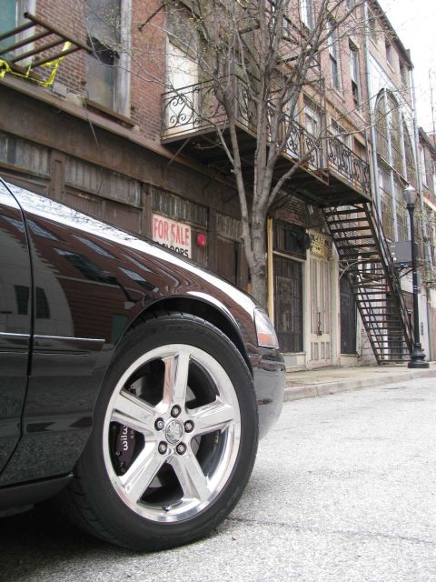2003 Mercury Marauder - A black 2003 Mercury Marauder is shown from the front quarter angle, parked on a street with old brick buildings.