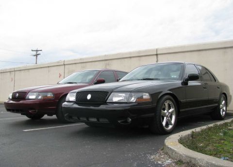 2003 Mercury Marauder - Two Mercury Marauders, a black and a maroon model, are parked next to each other.