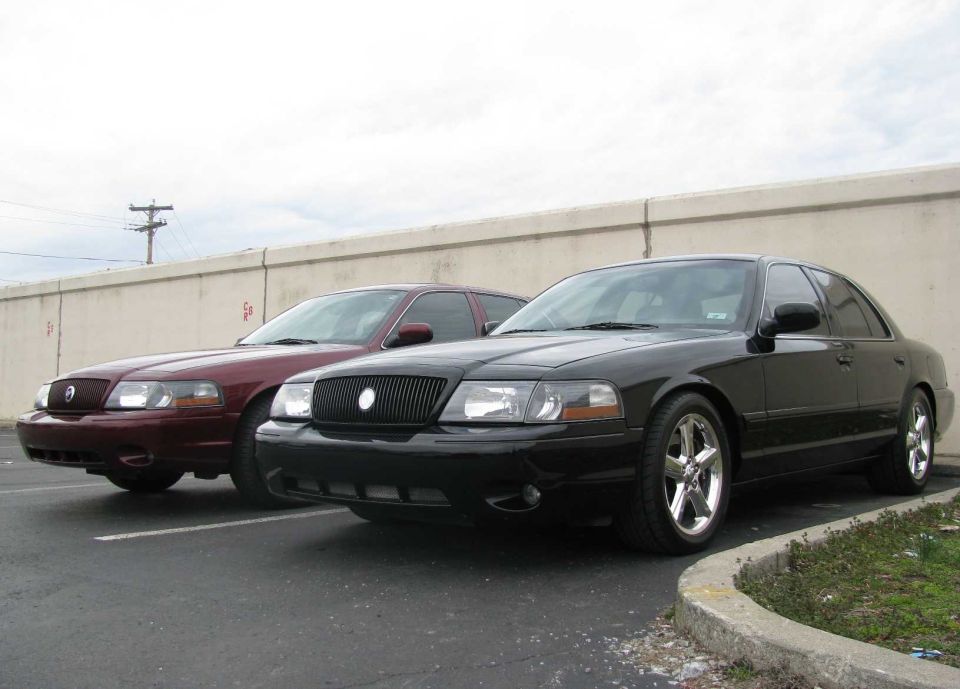 Black 2003 Mercury Marauder in front of a maroon one, parked on asphalt