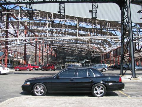 2003 Mercury Marauder - A black 2003 Mercury Marauder is parked in front of a large, open-air industrial building.