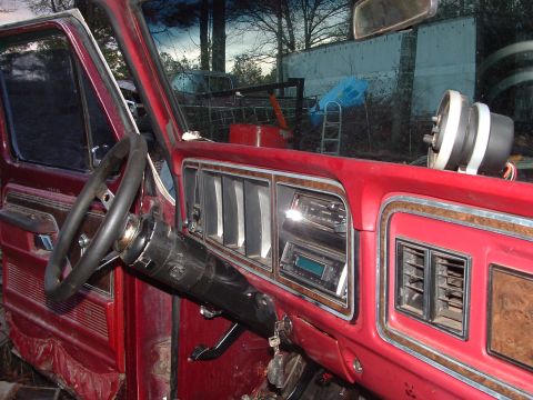 1979 Ford Bronco - Interior view of a red vehicle, wood trim accents and an aftermarket stereo system.