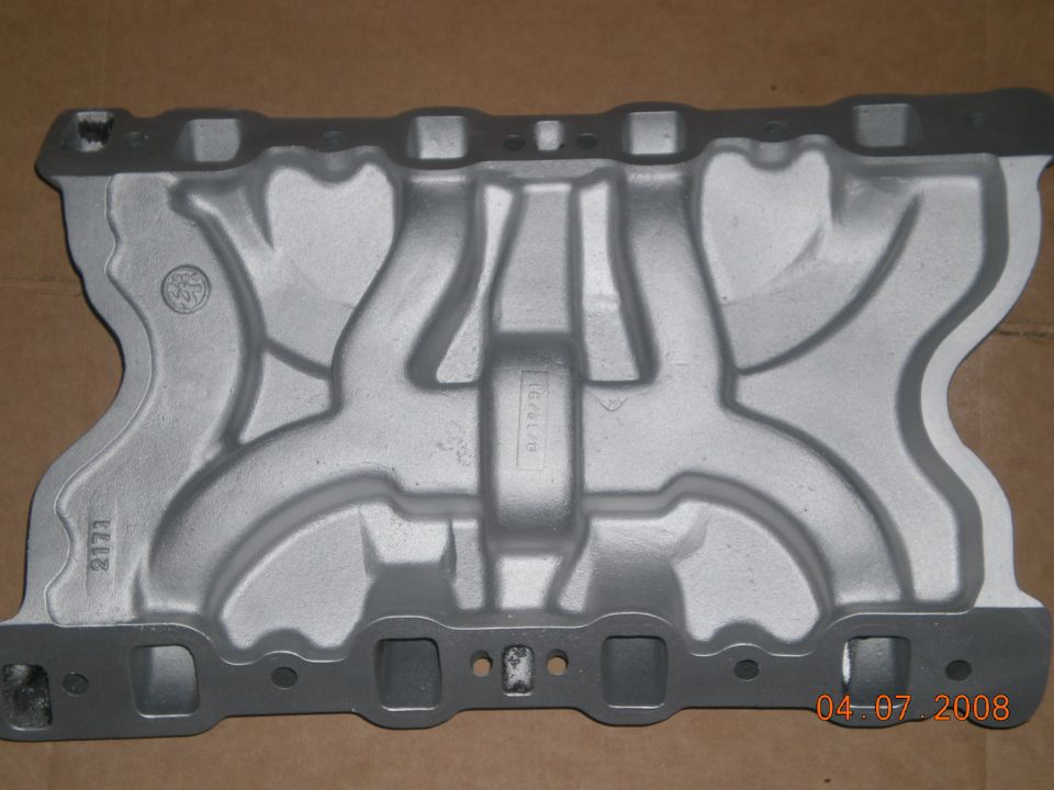 Aluminum intake manifold with visible casting marks and date stamp
