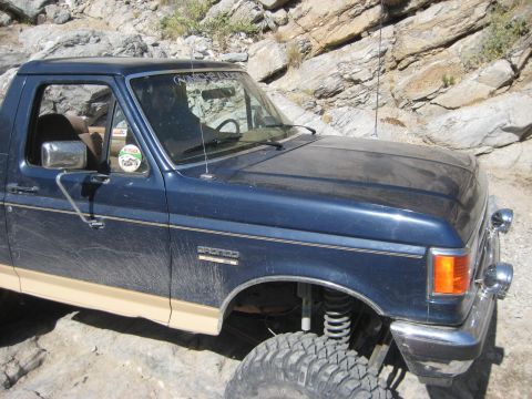 1991 Ford Bronco - This 1991 Ford Bronco is navigating a rocky off-road path, showing its front quarter view.