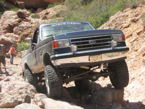 1991 Ford Bronco - A Ford F-Series truck is shown off-roading on a rocky trail.