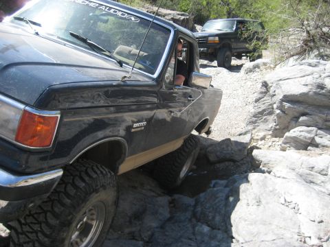 1991 Ford Bronco - Two Ford Broncos navigate a challenging rocky off-road trail, their off-road capabilities.