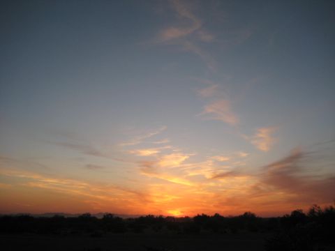 1991 Ford Bronco - A vibrant sunset paints the sky with warm colors above a silhouetted desert landscape.