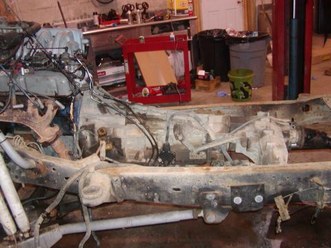1991 Ford Bronco - The chassis and powertrain components of a vehicle are visible, suggesting it is undergoing disassembly or repair.