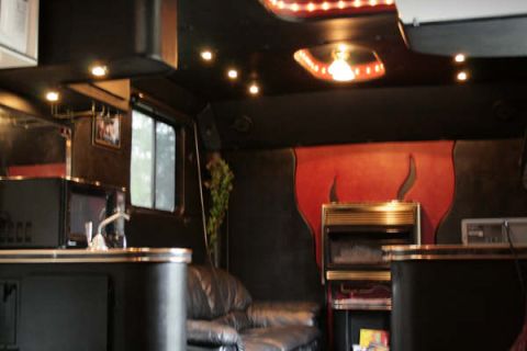 1993 Ford C-350 (Centurion Conversions) - Custom interior features a couch, microwave, and a unique fireplace design.